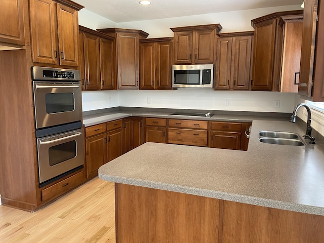 265 Gray Hawk Trl, Clarksville, TN 37043 - kitchen with a peninsula, light wood-style floors, recessed lighting, a sink, and stainless steel appliances