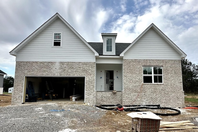 view of front of house with driveway and brick siding