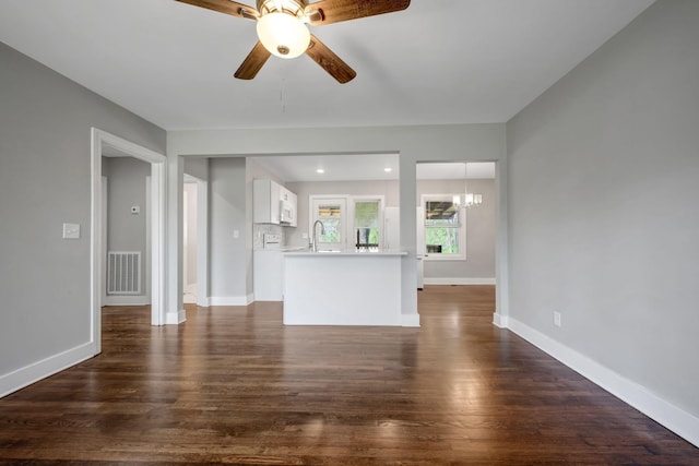 701 Santa Fe Pike, Columbia, TN 38401 - unfurnished living room featuring baseboards, dark wood-style floors, visible vents, ceiling fan with notable chandelier, and a sink