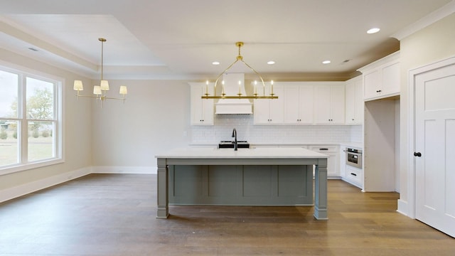 kitchen featuring a notable chandelier, a sink, dark wood-style floors, white cabinetry, and backsplash