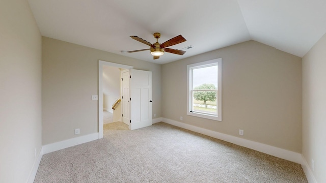 unfurnished bedroom featuring ceiling fan, vaulted ceiling, light carpet, and baseboards
