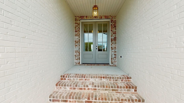 entrance to property featuring brick siding and french doors