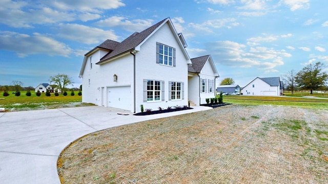 view of side of home featuring an attached garage, roof with shingles, driveway, and a lawn
