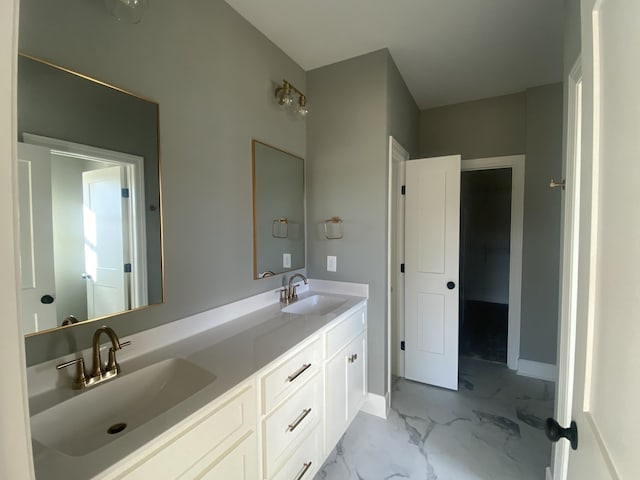 bathroom with double vanity, marble finish floor, and a sink