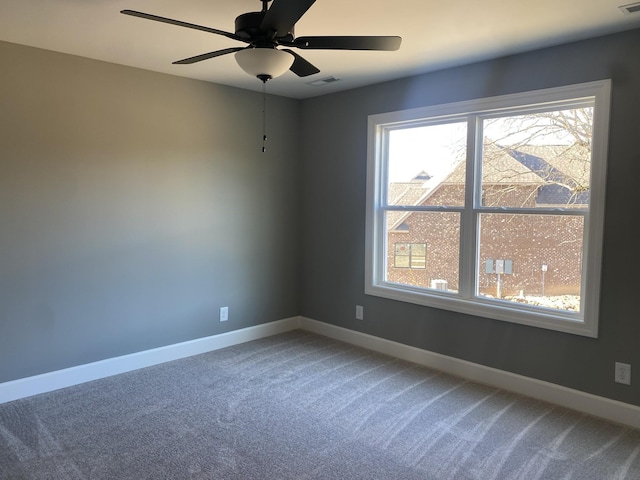 spare room featuring visible vents, light colored carpet, baseboards, and ceiling fan