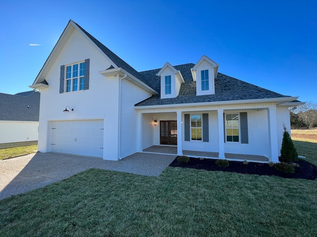 modern farmhouse with a shingled roof, an attached garage, brick siding, a front lawn, and driveway
