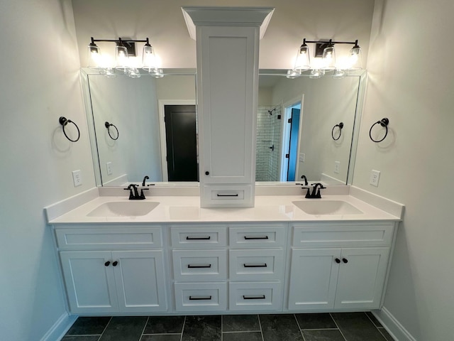bathroom with tile patterned floors, double vanity, a tile shower, and a sink