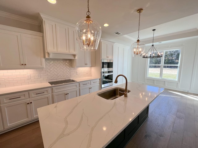kitchen featuring a sink, visible vents, an inviting chandelier, and black electric cooktop