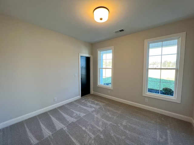 unfurnished room featuring visible vents, baseboards, and carpet floors