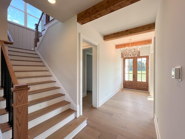 staircase with baseboards, a notable chandelier, beam ceiling, wood finished floors, and french doors