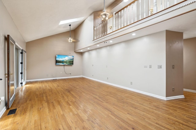empty room with wood finished floors, visible vents, and baseboards