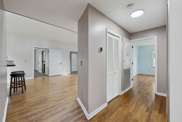 hallway featuring wood finished floors and baseboards