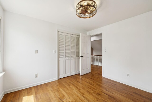 unfurnished bedroom featuring a closet, light wood finished floors, and baseboards