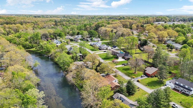birds eye view of property with a residential view, a wooded view, and a water view
