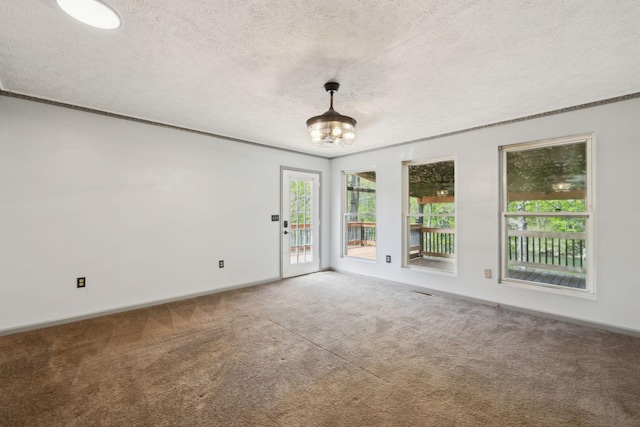 carpeted empty room with a notable chandelier, baseboards, crown molding, and a textured ceiling