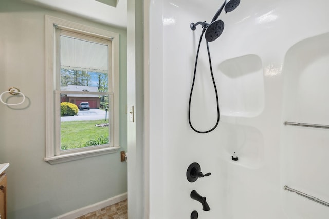 full bath featuring baseboards, vanity, and a shower