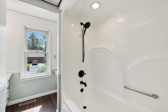 full bath with baseboards, wood finished floors, and visible vents