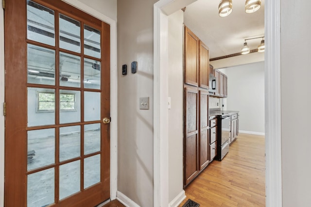 doorway to outside featuring light wood-style flooring and baseboards