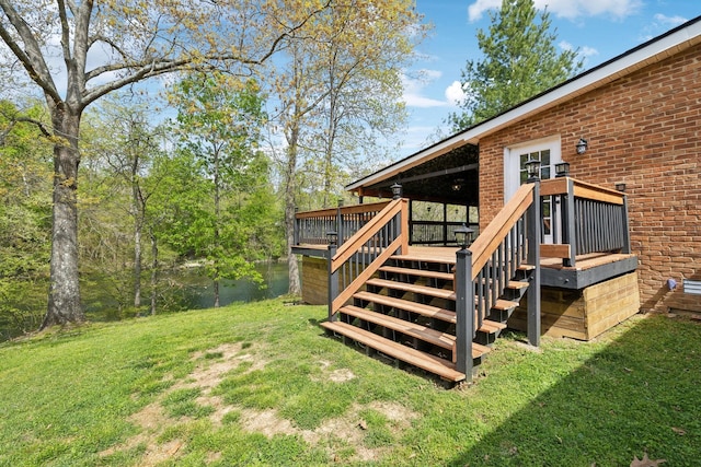 exterior space featuring stairway, a lawn, and a water view