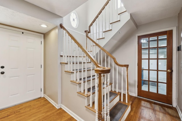 entryway featuring recessed lighting, wood finished floors, baseboards, and stairway