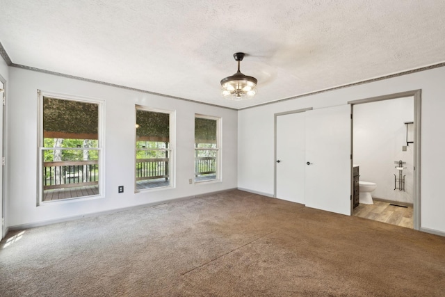 unfurnished bedroom featuring light colored carpet, ornamental molding, multiple windows, and a textured ceiling
