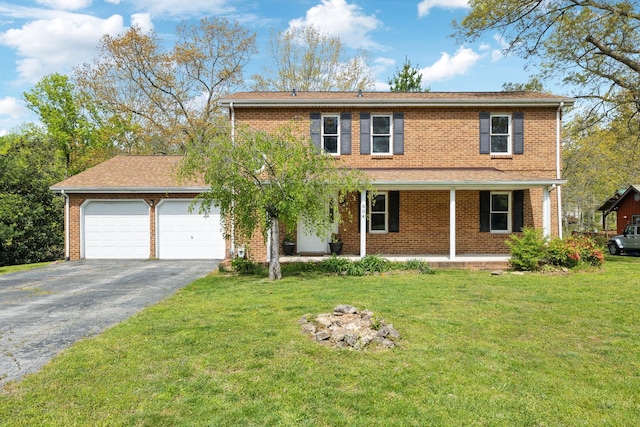 traditional-style house featuring driveway, covered porch, an attached garage, a front yard, and brick siding