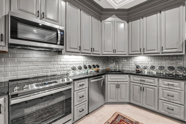 328 White Swans Xing, Brentwood, TN 37027 - kitchen featuring dark stone counters, light tile patterned floors, a sink, stainless steel appliances, and decorative backsplash