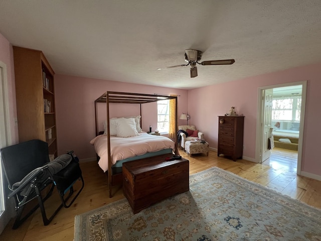 bedroom with baseboards, light wood-type flooring, ceiling fan, and multiple windows