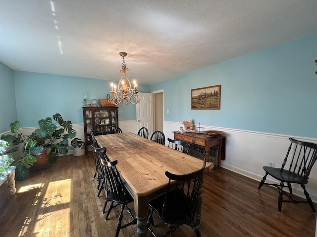 dining space featuring baseboards, an inviting chandelier, and wood finished floors