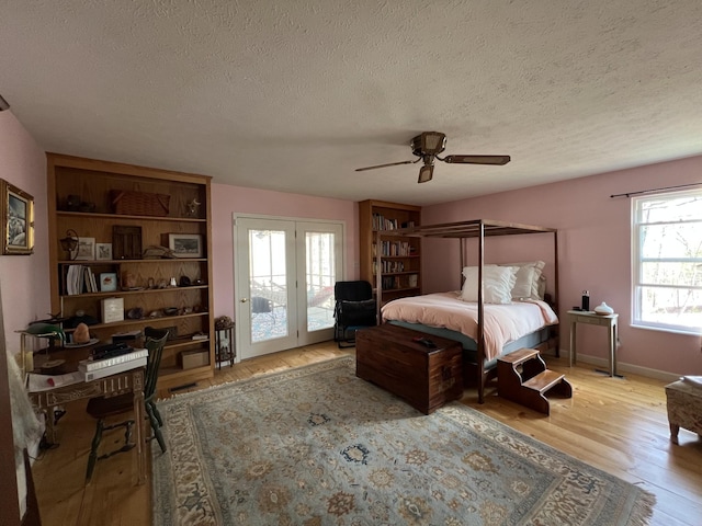 bedroom featuring access to exterior, light wood finished floors, ceiling fan, and a textured ceiling
