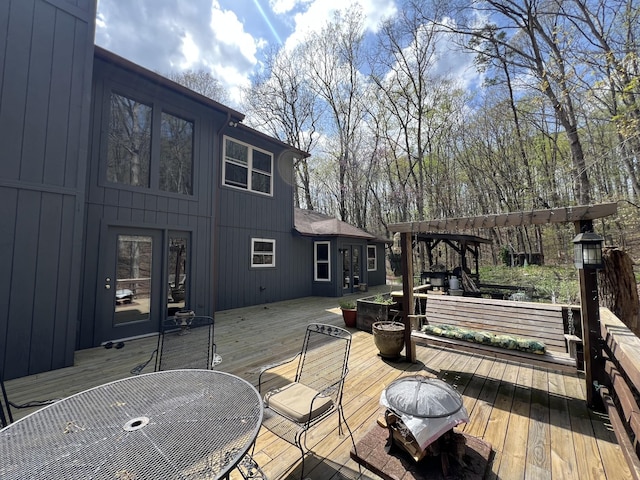wooden deck with outdoor dining space and a pergola