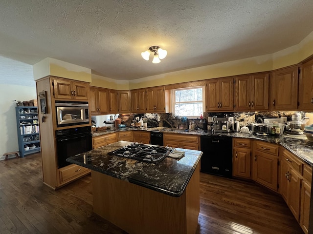 kitchen featuring a center island, dark wood-style flooring, a textured ceiling, brown cabinetry, and black appliances