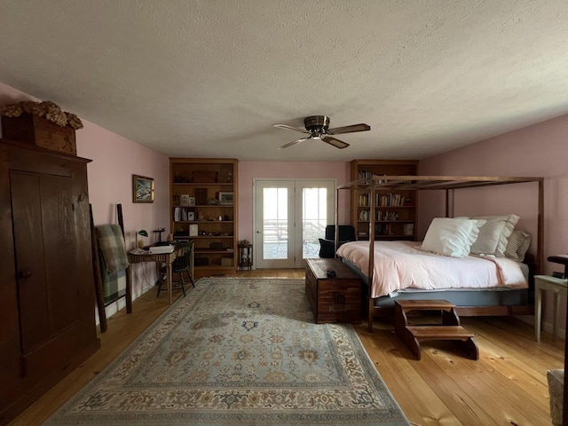 bedroom featuring a ceiling fan, wood finished floors, and a textured ceiling