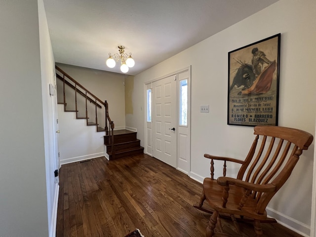 entryway featuring visible vents, wood finished floors, stairs, a notable chandelier, and baseboards