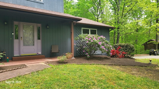 property entrance featuring board and batten siding, a porch, and a yard