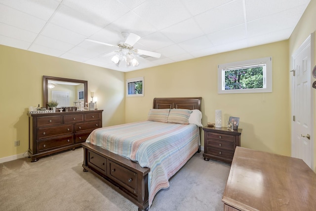 bedroom featuring light colored carpet, ceiling fan, and a drop ceiling