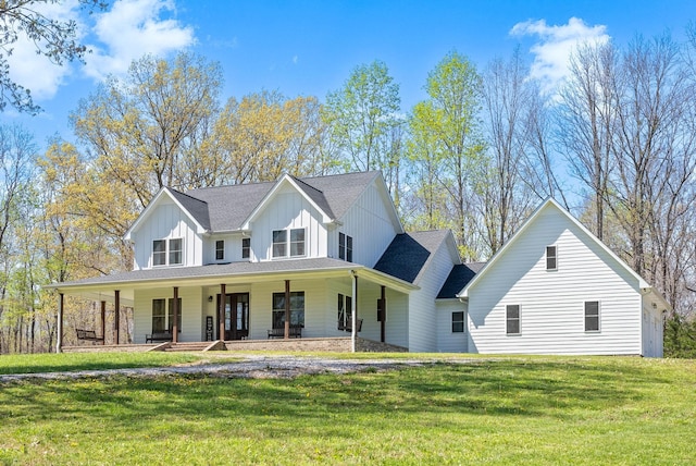 view of front of house with board and batten siding, a front lawn, and covered porch