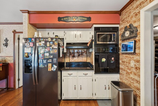 124 Timber Trail Dr, Lebanon, TN 37090 - kitchen featuring dark countertops, crown molding, black appliances, under cabinet range hood, and dark wood-style floors