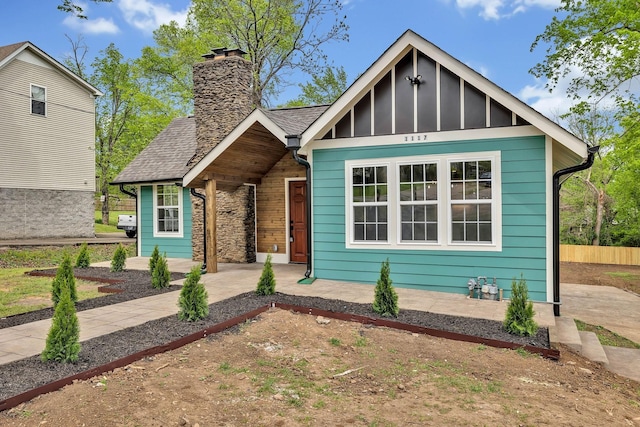 view of front of house featuring roof with shingles and a chimney