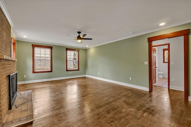 unfurnished living room featuring baseboards, a brick fireplace, ornamental molding, a ceiling fan, and dark wood-style floors