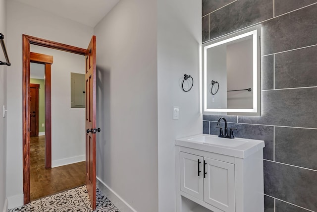 bathroom featuring baseboards, vanity, and electric panel