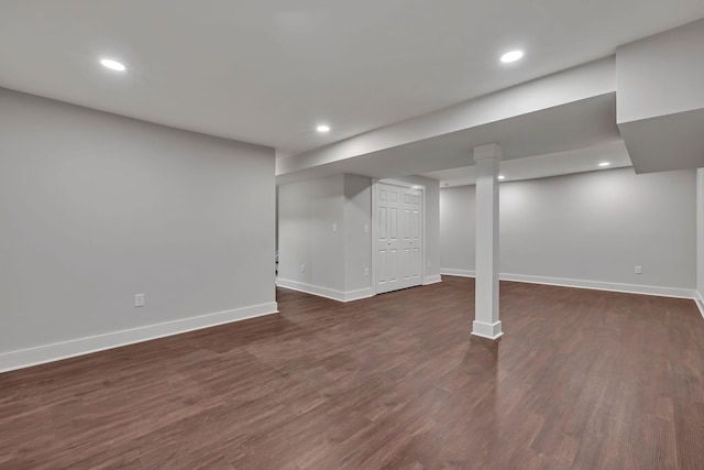 finished basement with recessed lighting, dark wood-type flooring, and baseboards