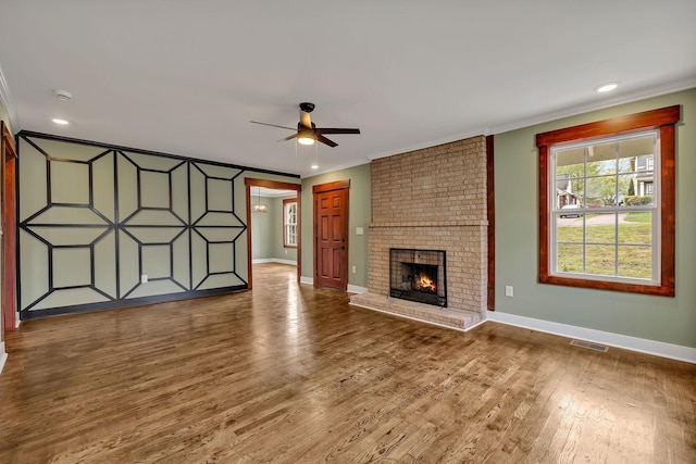 unfurnished living room with visible vents, baseboards, crown molding, and a ceiling fan