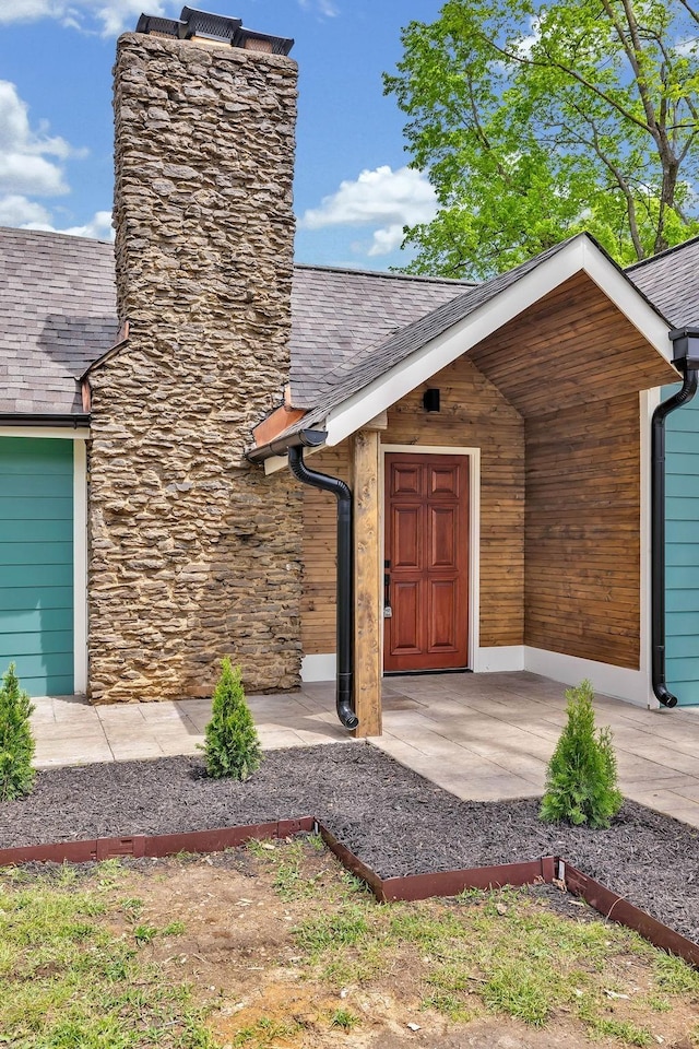 property entrance featuring roof with shingles