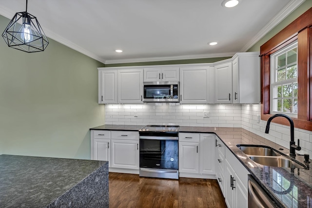 kitchen with hanging light fixtures, white cabinets, a sink, ornamental molding, and stainless steel appliances