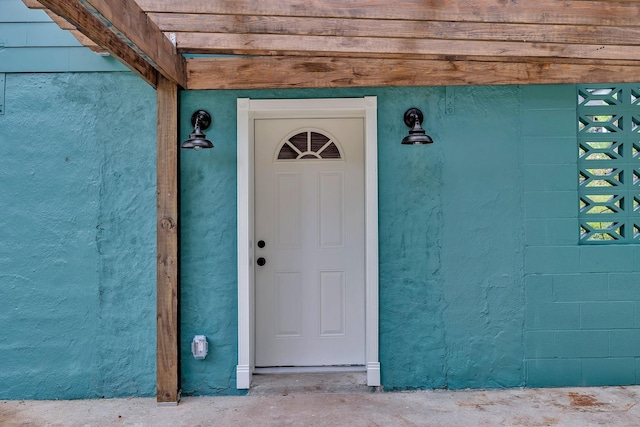 view of exterior entry featuring stucco siding