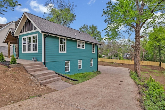 view of side of home with driveway and fence