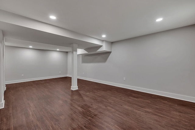 finished below grade area with baseboards, dark wood finished floors, and recessed lighting