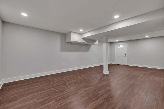 finished below grade area featuring dark wood-type flooring, baseboards, and recessed lighting