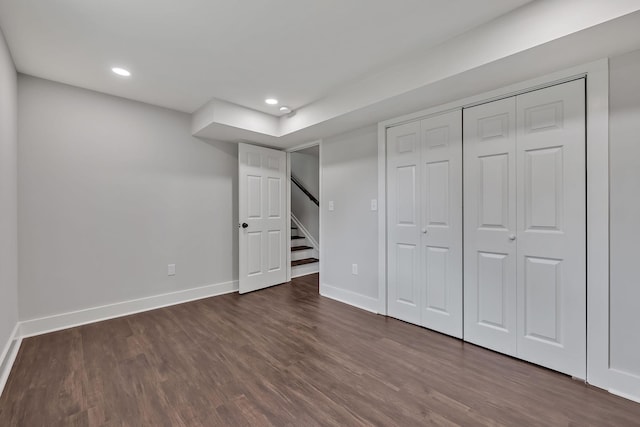 unfurnished bedroom with dark wood-style flooring, a closet, baseboards, and recessed lighting